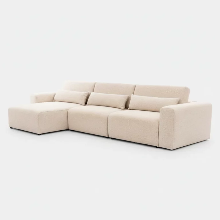 Canapé Vela Maison Du Monde en tissu beige, modulable, avec méridienne, accoudoirs droits, coussins assortis, vu en angle.