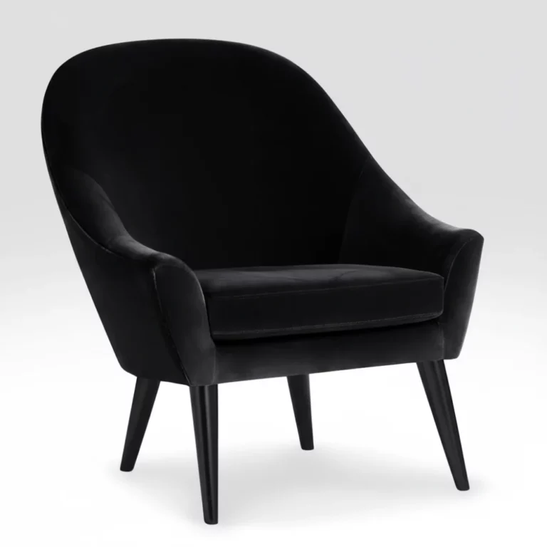 Fauteuil Dakota Conforama en velours noir, silhouette arrondie, pieds en bois noir, coussin d'assise épais, vue de trois quarts.
