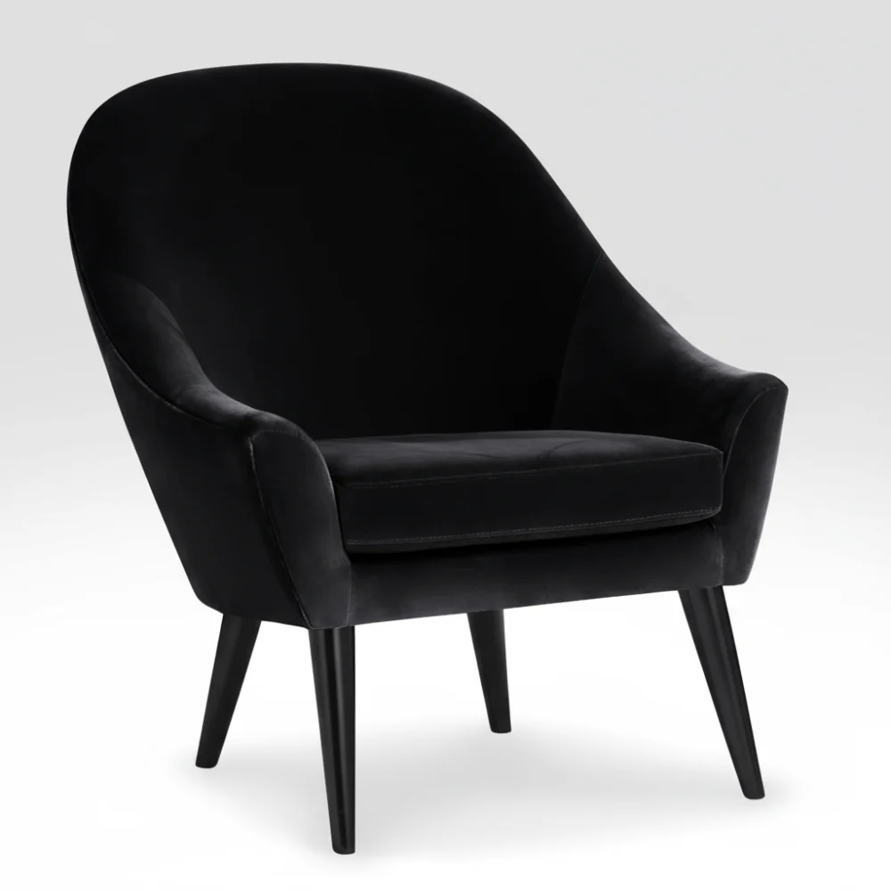 Fauteuil Dakota Conforama en velours noir, silhouette arrondie, pieds en bois noir, coussin d'assise épais, vue de trois quarts.