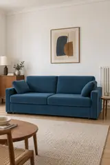 Vue d'ensemble du canapé Timor La Redoute 3 places convertible en velours, coloris bleu de prusse, style contemporain, dans un petit salon d'appartement (mise en situation illustrée par IA)