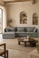 Vue d'ensemble du canapé Camille AM.PM d'angle en tissu, coloris anthracite, style campagne chic, dans un salon (mise en situation illustrée par IA)