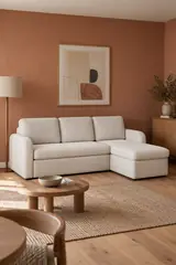 Vue d'ensemble du canapé Milano La Redoute d'angle convertible en bouclette, coloris ivoire, style contemporain, dans un séjour au mur terracotta (mise en situation illustrée par IA)