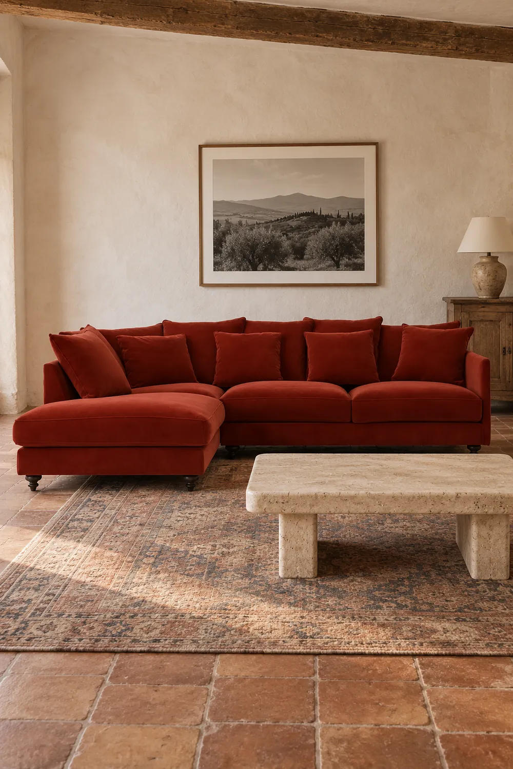 Vue d'ensemble du canapé Lazare La Redoute d'angle convertible en velours, coloris rouge cinabre, style classique, dans une maison de campagne (mise en situation illustrée par IA)