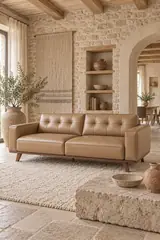 Vue d'ensemble du canapé chester Maisons du Monde 3 places en cuir, coloris sable et pied noyer, style chesterfield, dans un salon (mise en situation illustrée par IA)