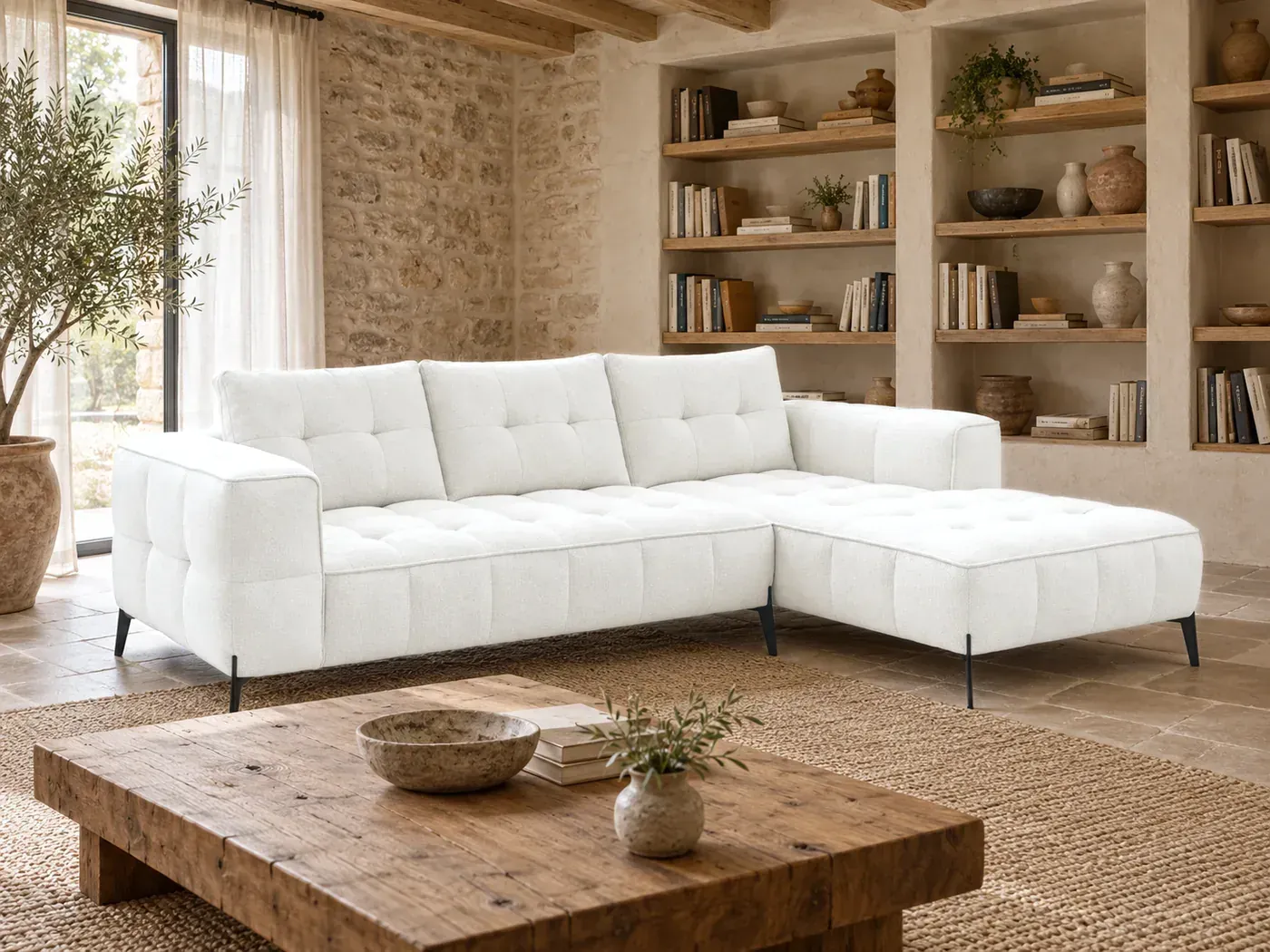 Anis, 4 places d'angle fixe, tissu texturé, coloris blanc, dans un salon en pierre avec une bibliothèque en chêne