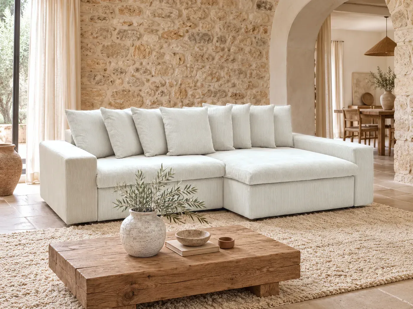 Enore, 3 places d'angle fixe, velours côtelé, coloris beige, dans un salon en pierre blonde avec une arche chaulée